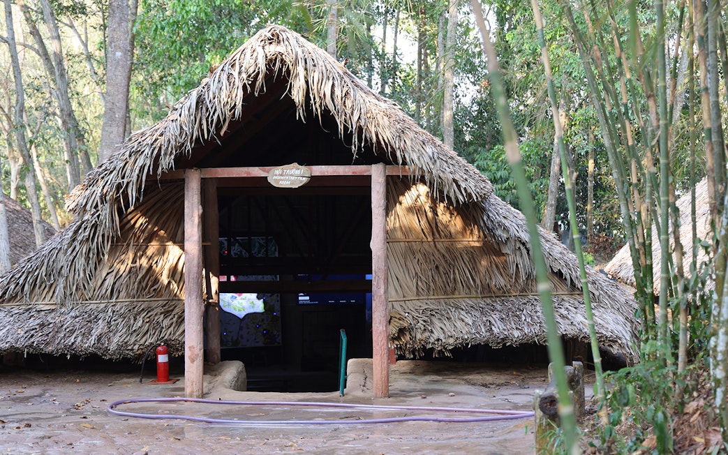 Hut room entrance at Cu Chi Tunnels surrounded by trees.