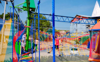 Children playing on colorful climbing nets at a birthday party venue in Phuket.