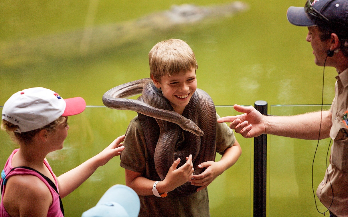 Boy holding a snake at Hartleys Crocodile Adventures, Queensland.