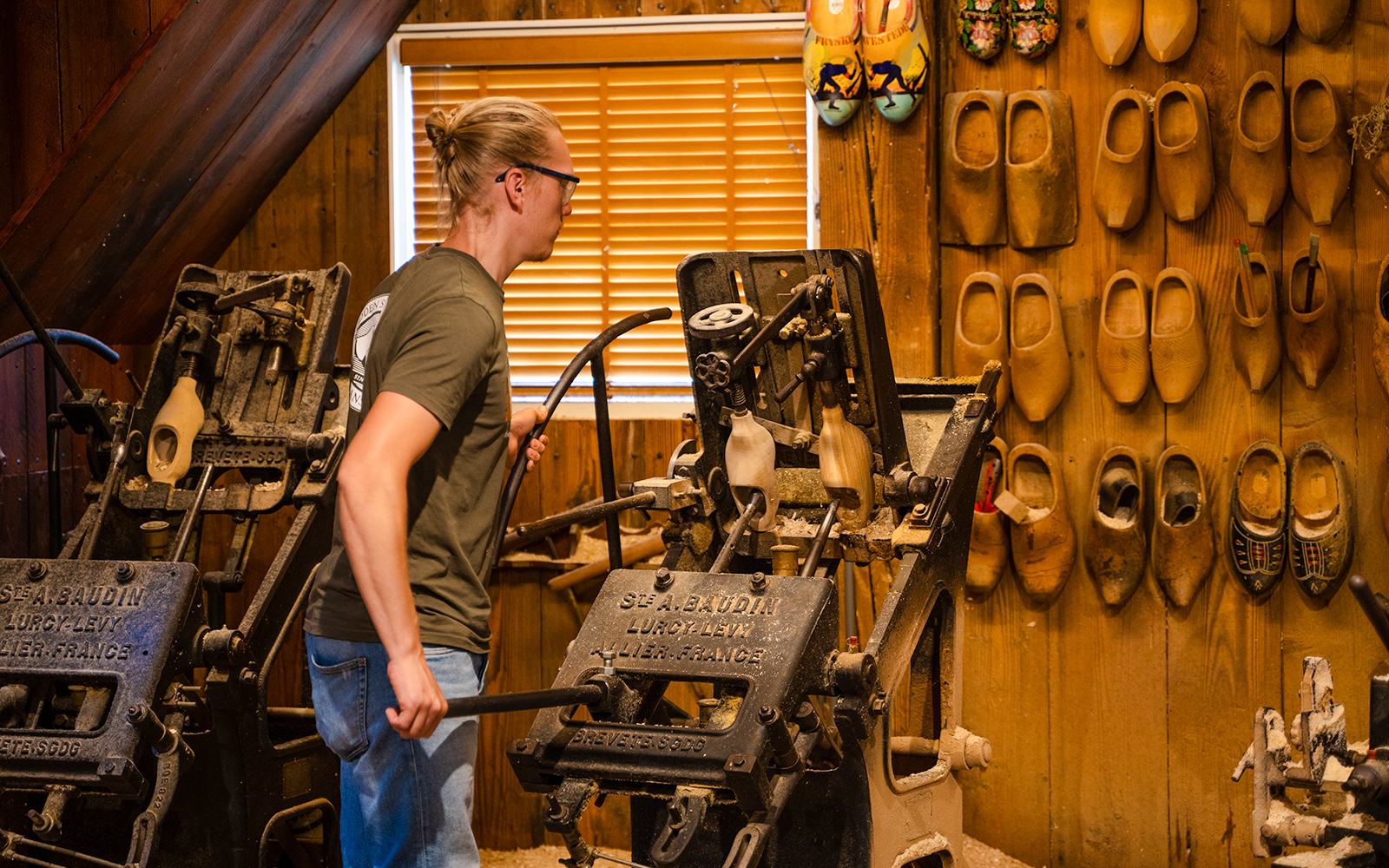 Traditional clog making demonstration with machinery and wooden clogs on display.