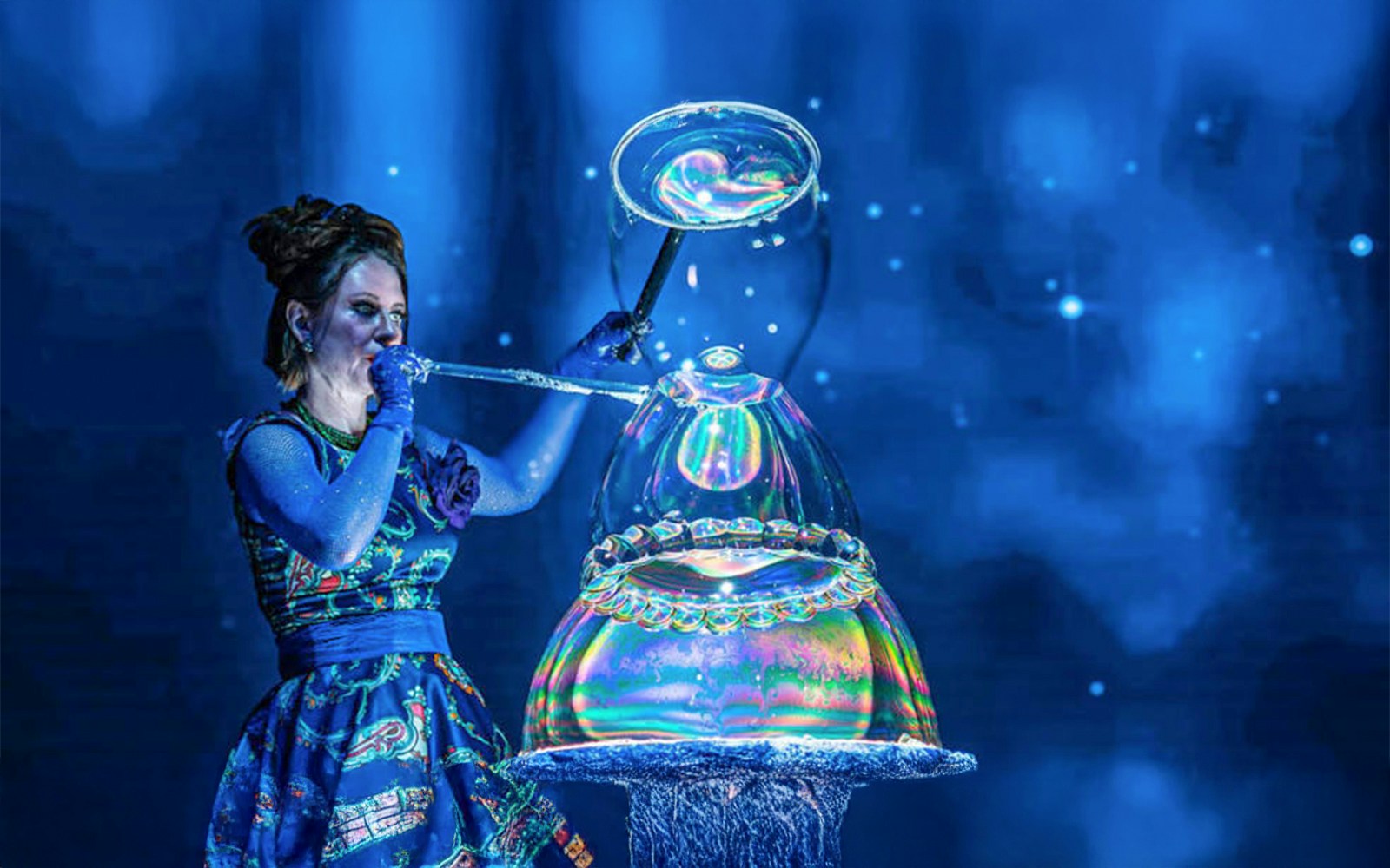 Lady in a blue dress on a stage performing the Magic Bubble Live Show