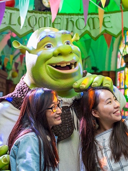 Visitors posing with Shrek at Shrek's Adventure in London.