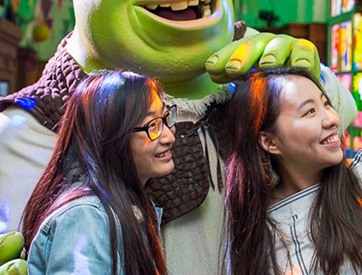 Visitors posing with Shrek at Shrek's Adventure in London.