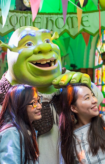 Visitors posing with Shrek at Shrek's Adventure in London.
