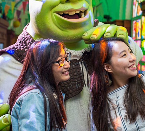 Visitors posing with Shrek at Shrek's Adventure in London.
