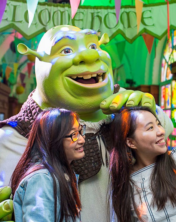 Visitors posing with Shrek at Shrek's Adventure in London.