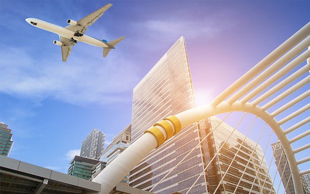 Airplane flying over modern architecture in Kota Kinabalu, Malaysia.