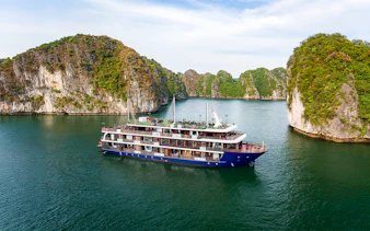 Cruise ship sailing through Lan Ha Bay with limestone karsts in the background.