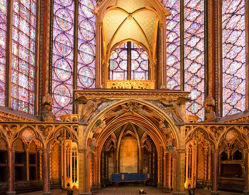 Stained glass windows inside Sainte-Chapelle, Paris, showcasing intricate biblical scenes.