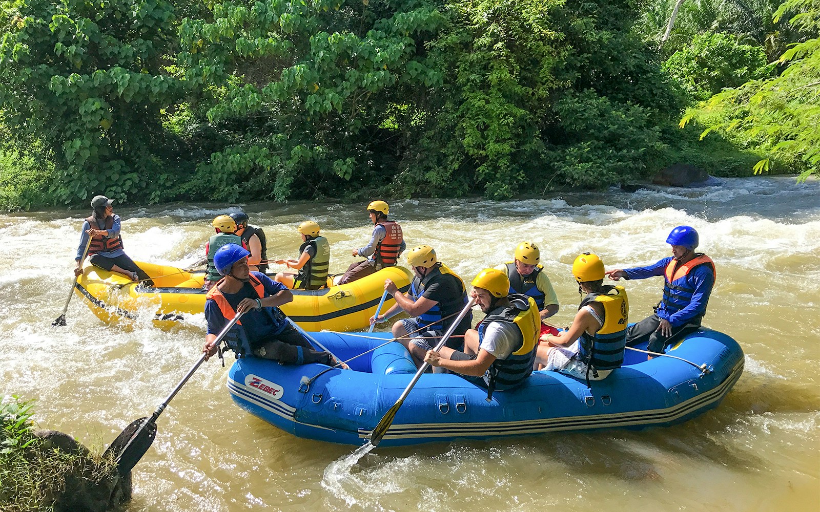 Group of tourists enjoying a full day adventure in Phuket, visiting the iconic Chalong Temple, experiencing thrilling rafting, and a memorable 30-minute elephant ride