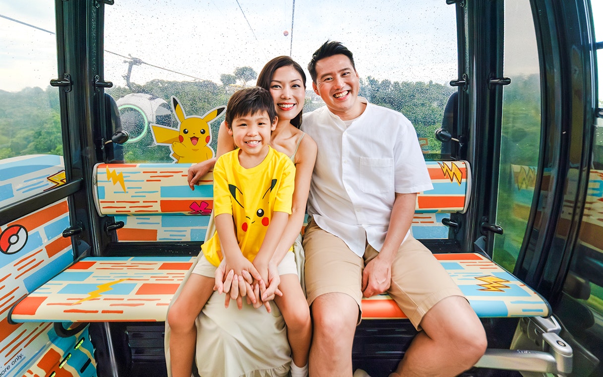 Family enjoying a Pokemon-themed cable car ride on Sentosa Island, Singapore.