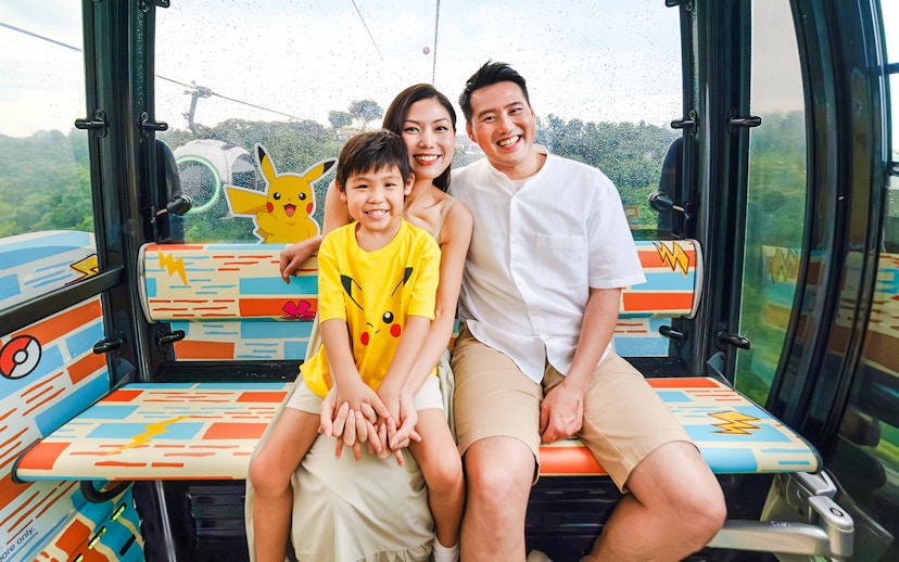 Family enjoying a Pokemon-themed cable car ride on Sentosa Island, Singapore.