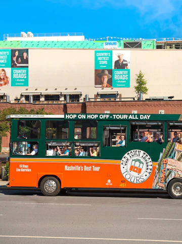 Old Town Trolley Tours bus in Nashville with passengers, city backdrop.