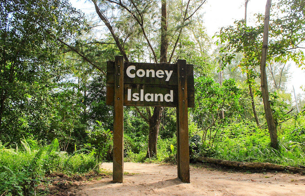 Coney Island entrance sign surrounded by lush greenery, Singapore.