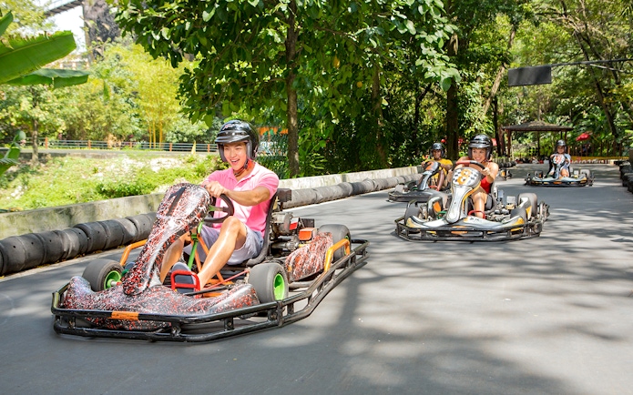 Go karting track at Sunway Lagoon theme park with racers in helmets.
