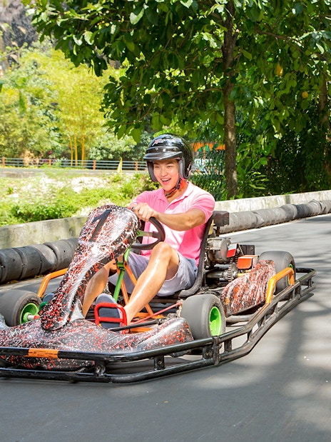 Go karting track at Sunway Lagoon theme park with racers in helmets.