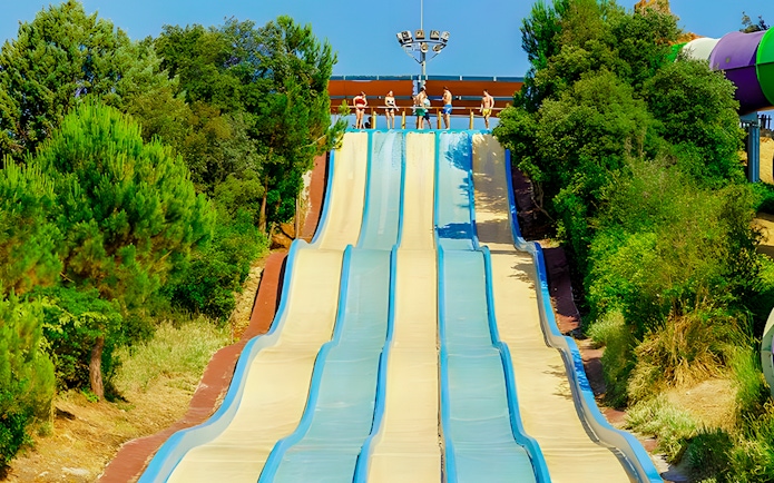 Water slides at Aquopolis Villanueva de la Cañada surrounded by trees.