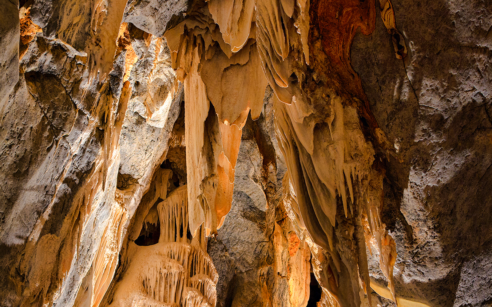 Limestone cave formations with stalactites and stalagmites.