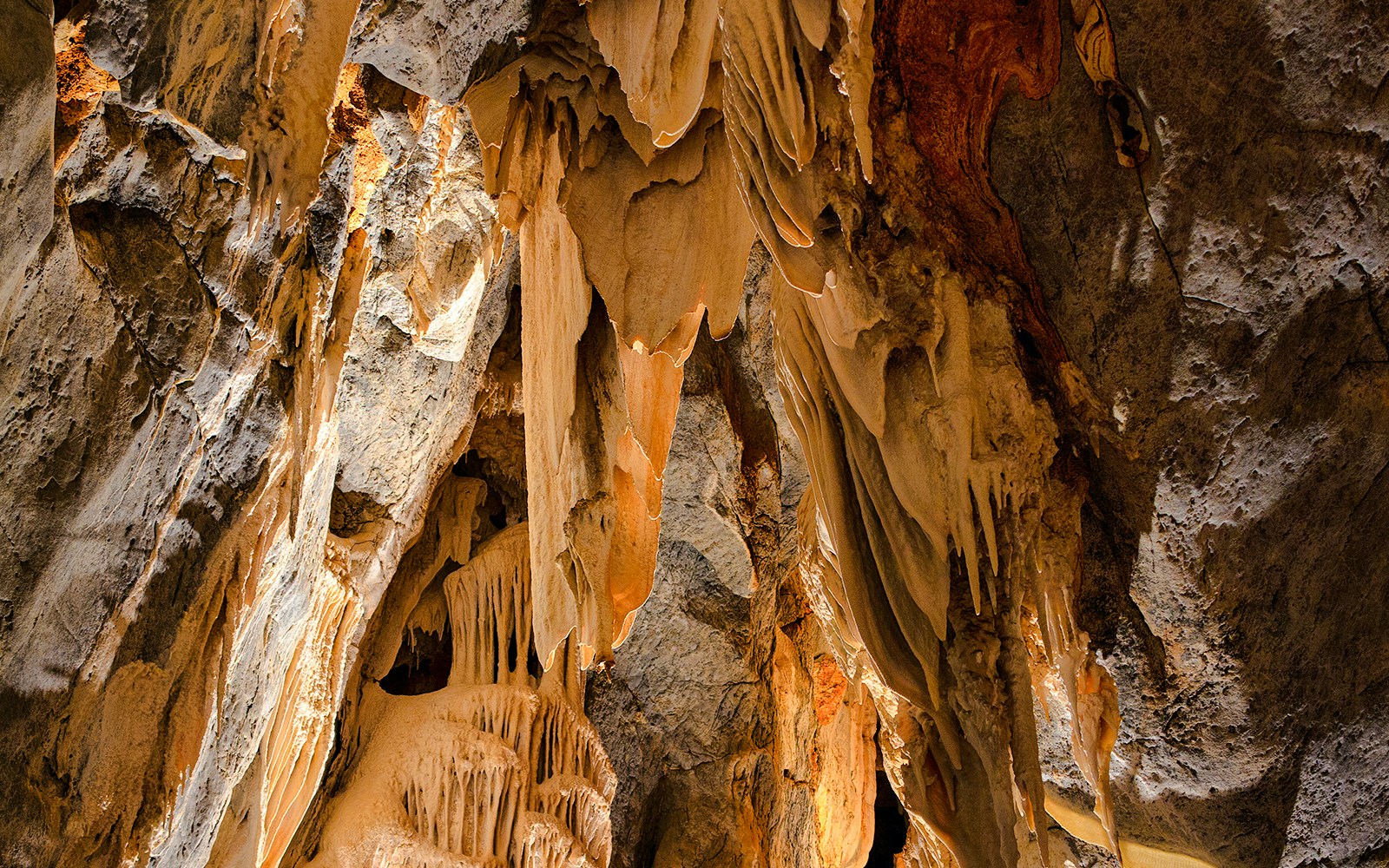Limestone cave formations with stalactites and stalagmites.