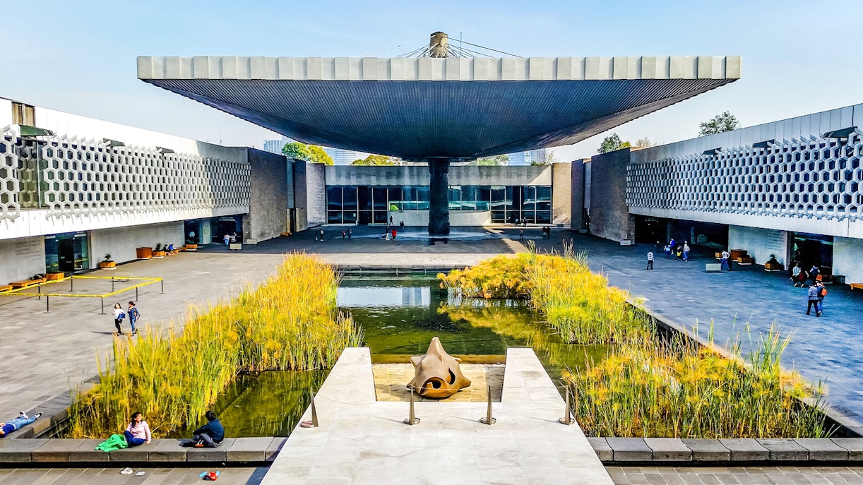 Anthropology Museum entrance with visitors exploring exhibits in Mexico City.