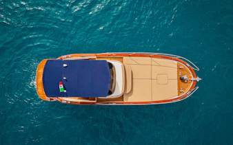 Aerial view of a boat cruising on the Amalfi Coast's blue waters.