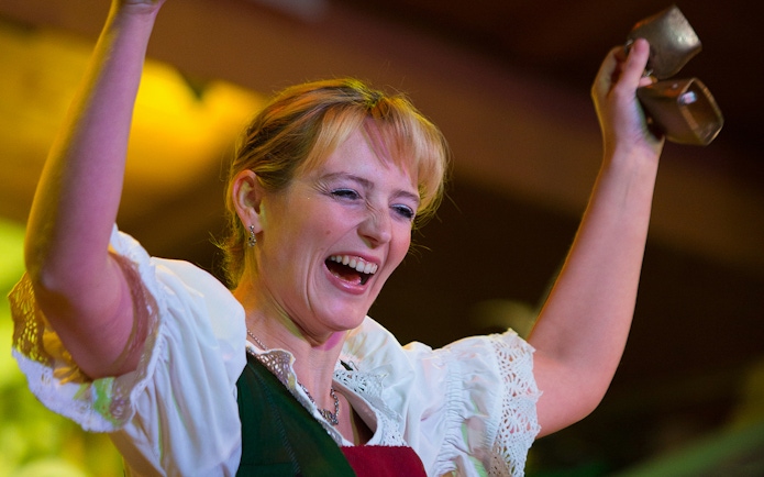 Performer at Tyrolean Evening Folk Show with Gundolf Family, holding cowbells.