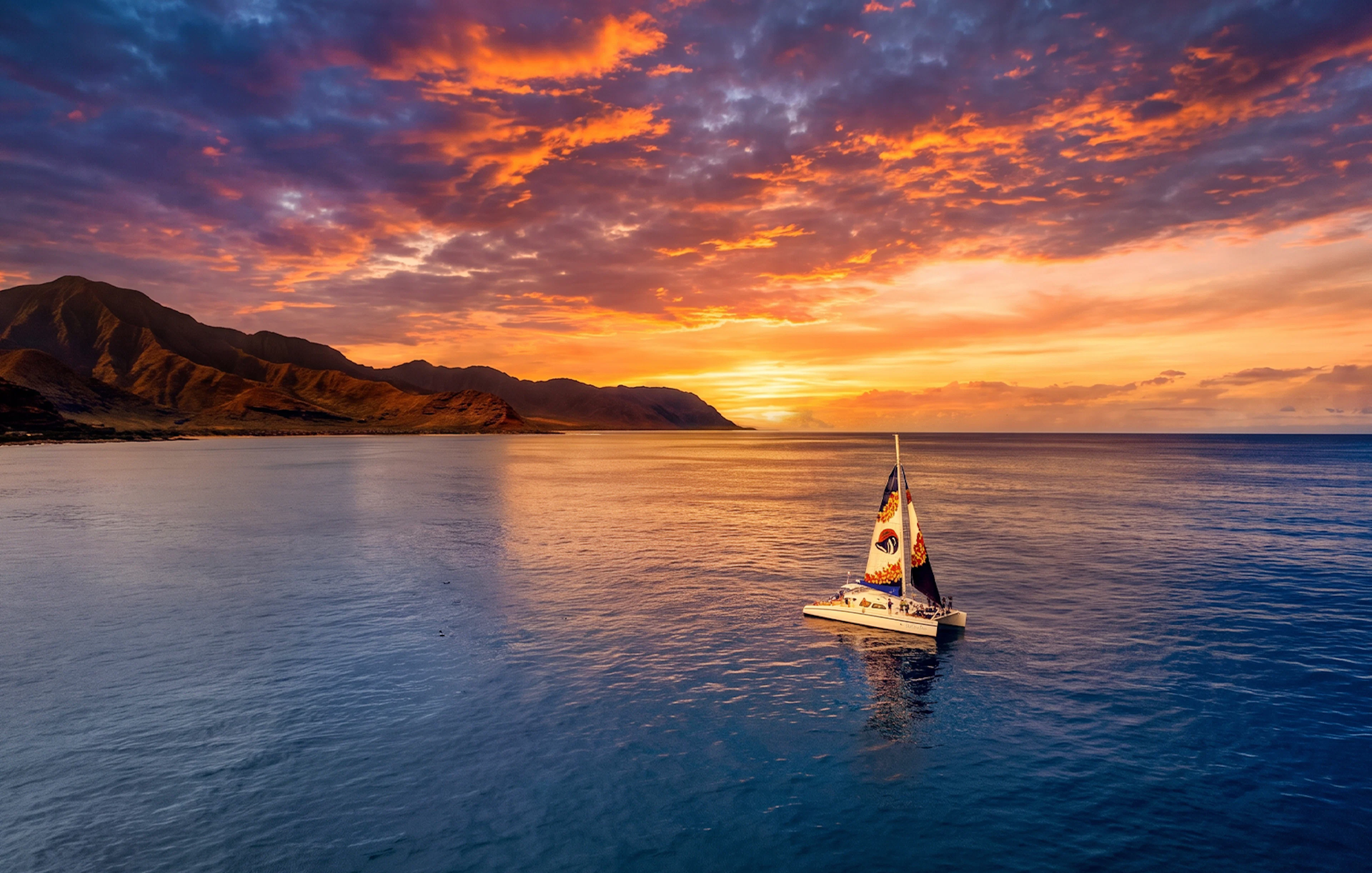 Catamaran sailing at sunset off the coast of West Oahu, Hawaii.