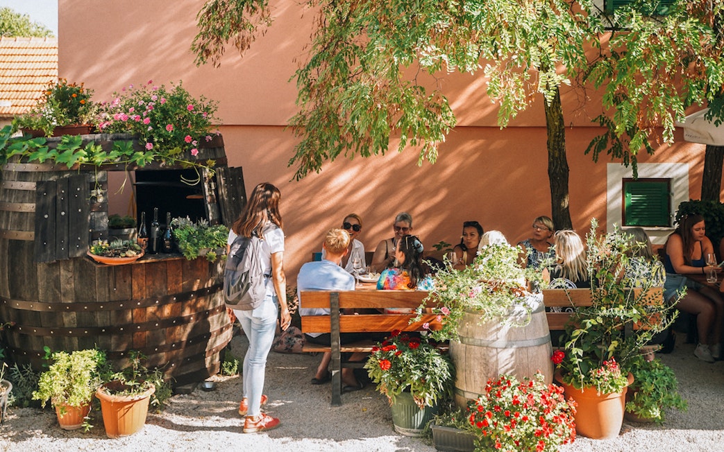 Group enjoying wine tasting at a rustic outdoor setting near Krka Waterfalls, Split.