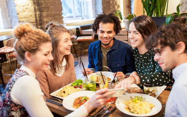 Group enjoying a meal at Brasserie Rosalie, sharing dishes and drinks.