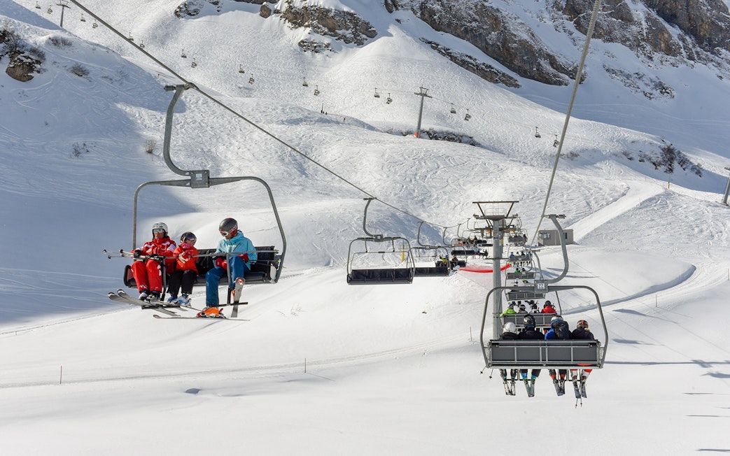 Chairlift with skiers ascending snowy slopes at Engelberg, Switzerland.