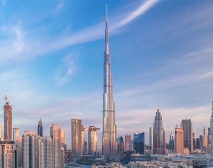 Burj Khalifa towering over Dubai skyline at sunset.