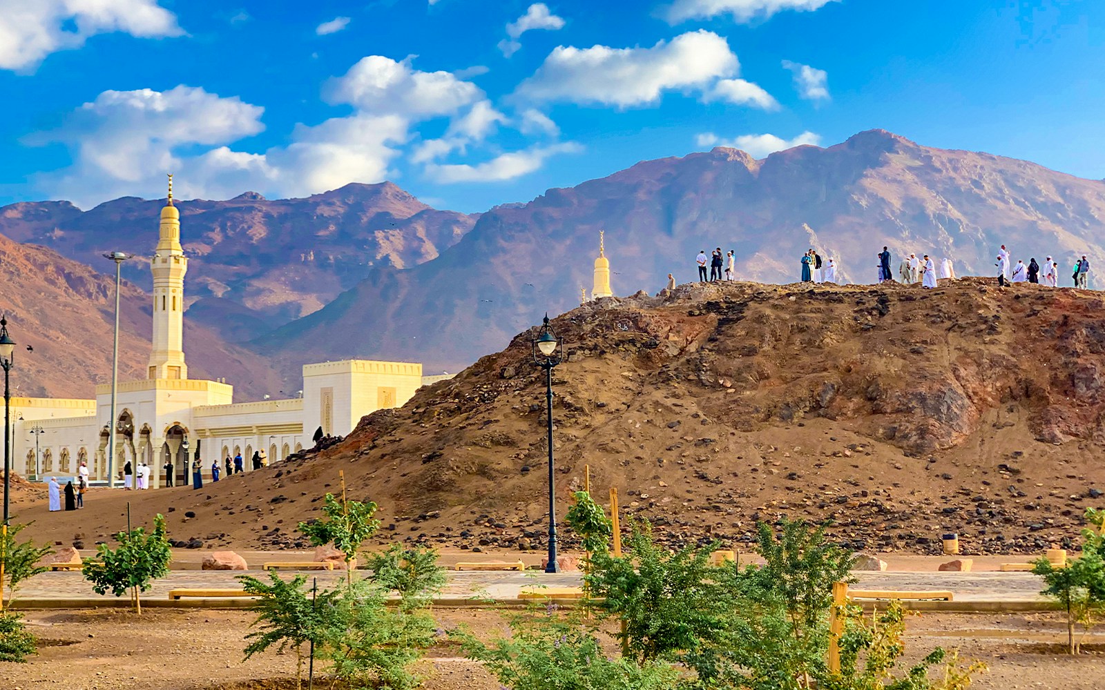 Visitors at Uhud Mountain with mosque and mountains in Medina, Saudi Arabia.