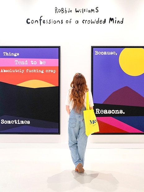 Visitor viewing colorful artwork at Moco Museum Barcelona exhibition.