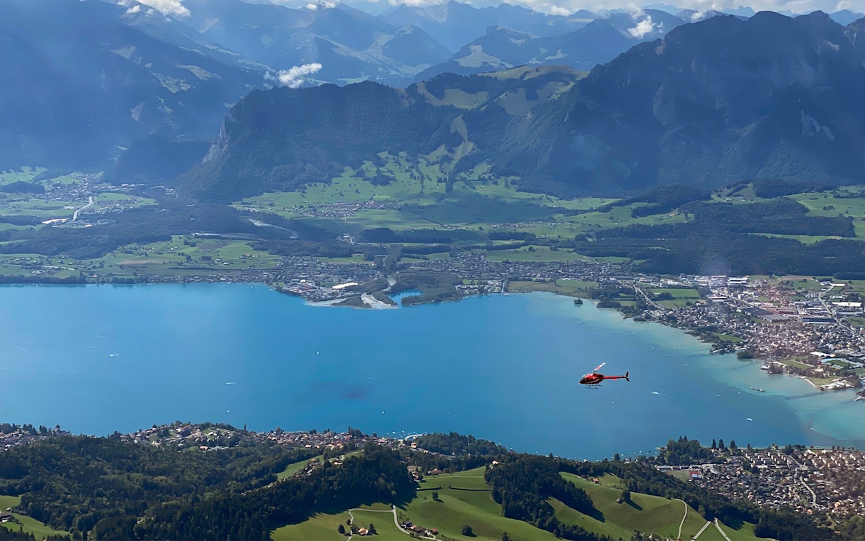 Helicopter flying over Stockhorn Mountain with view of lake and landscape from Bern-Belp Airport.