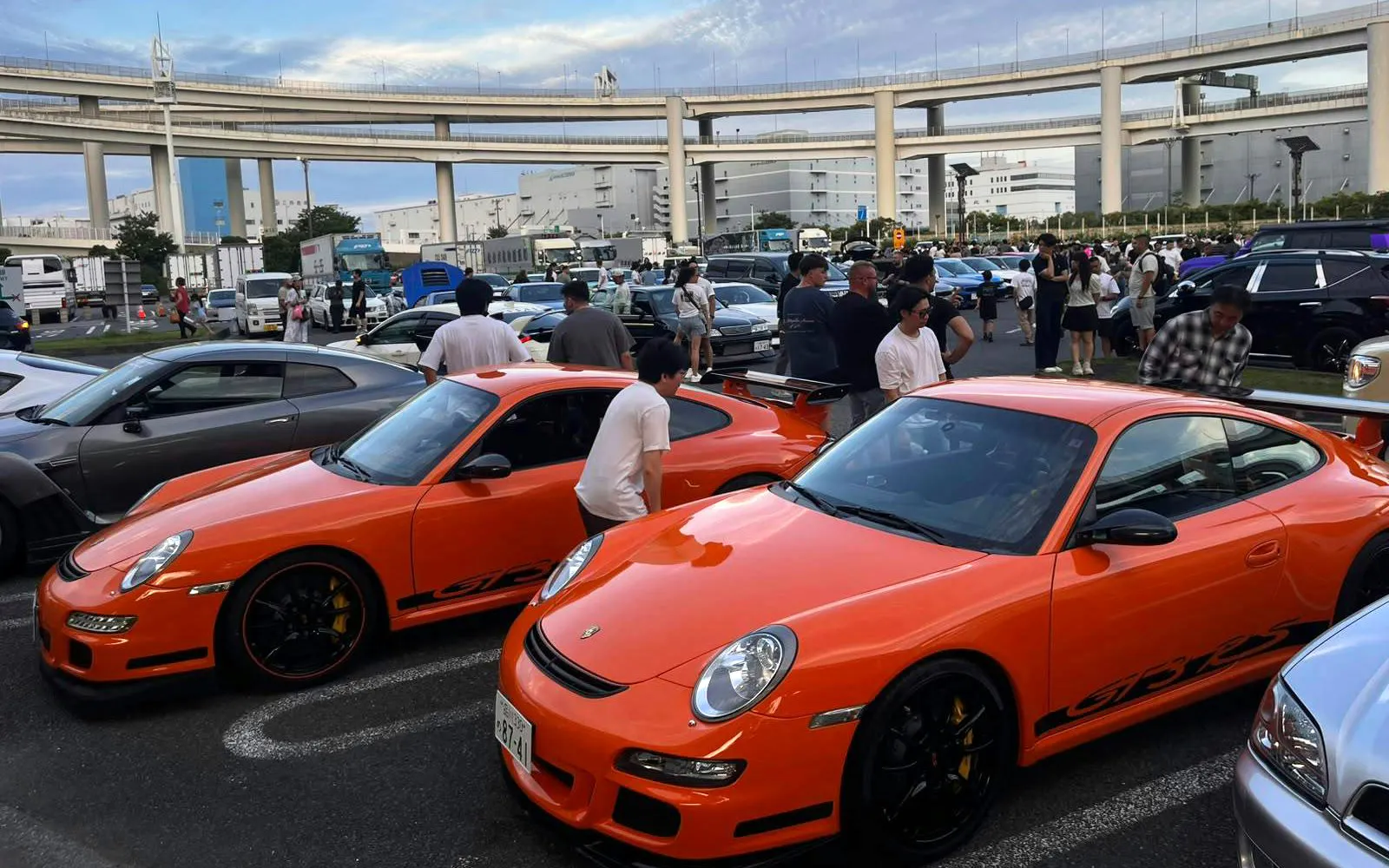 Orange sports cars at a Tokyo car meet, part of the Fast and the Furious Tokyo Drift III Experience.