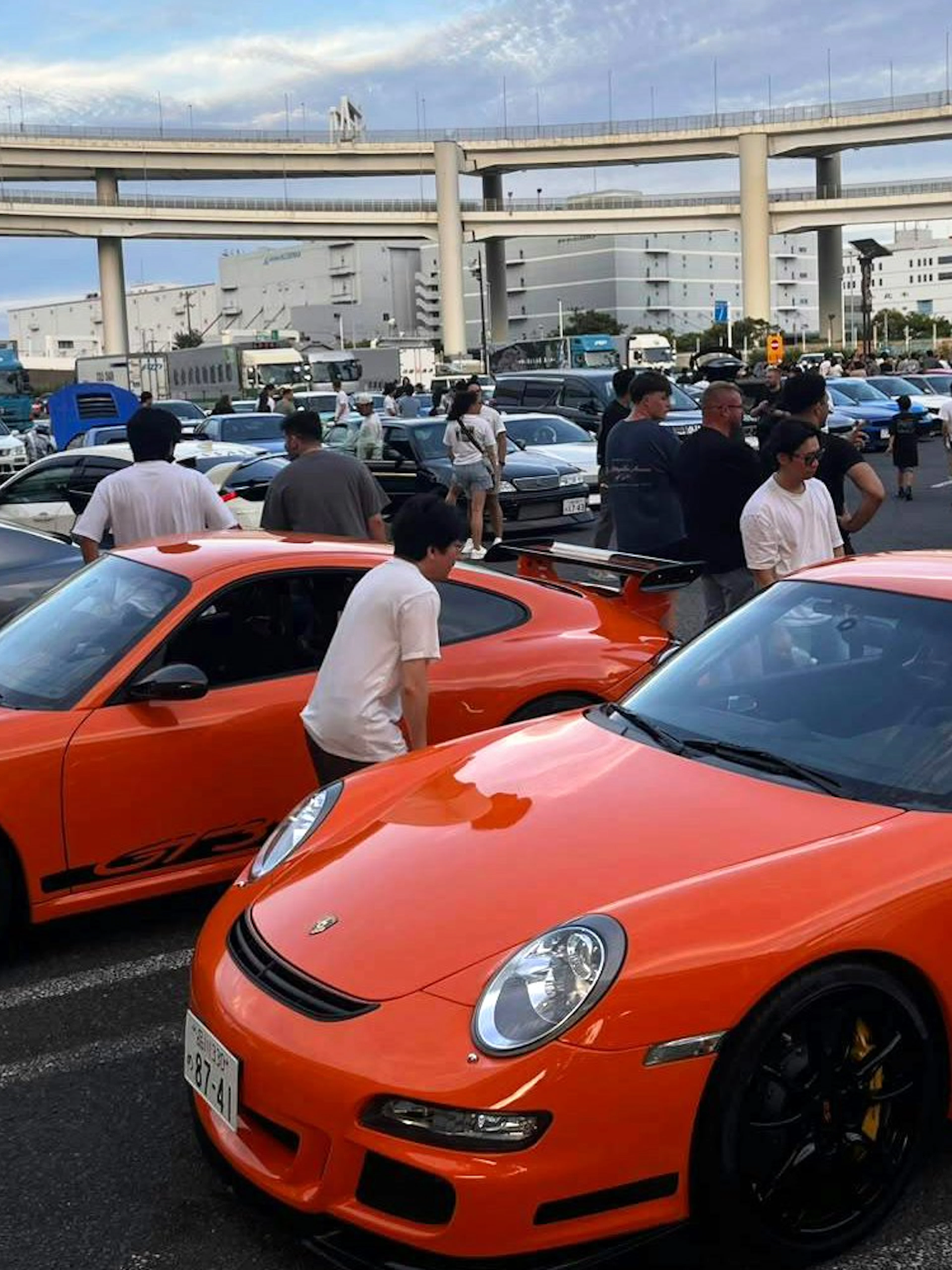 Orange sports cars at a Tokyo car meet, part of the Fast and the Furious Tokyo Drift III Experience.