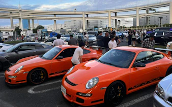 Orange sports cars at a Tokyo car meet, part of the Fast and the Furious Tokyo Drift III Experience.