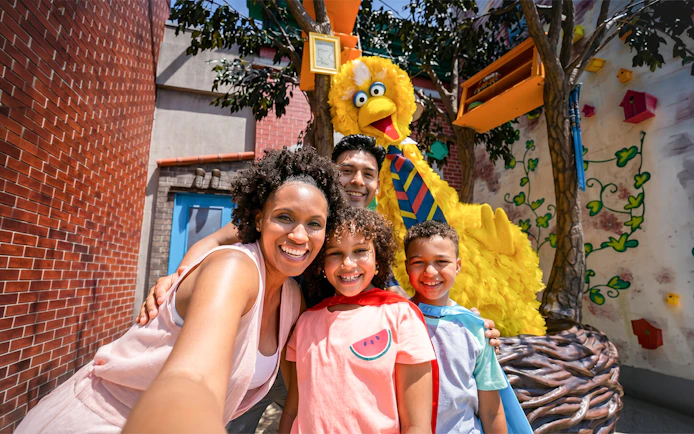 Family posing with Big Bird at Sesame Place San Diego.
