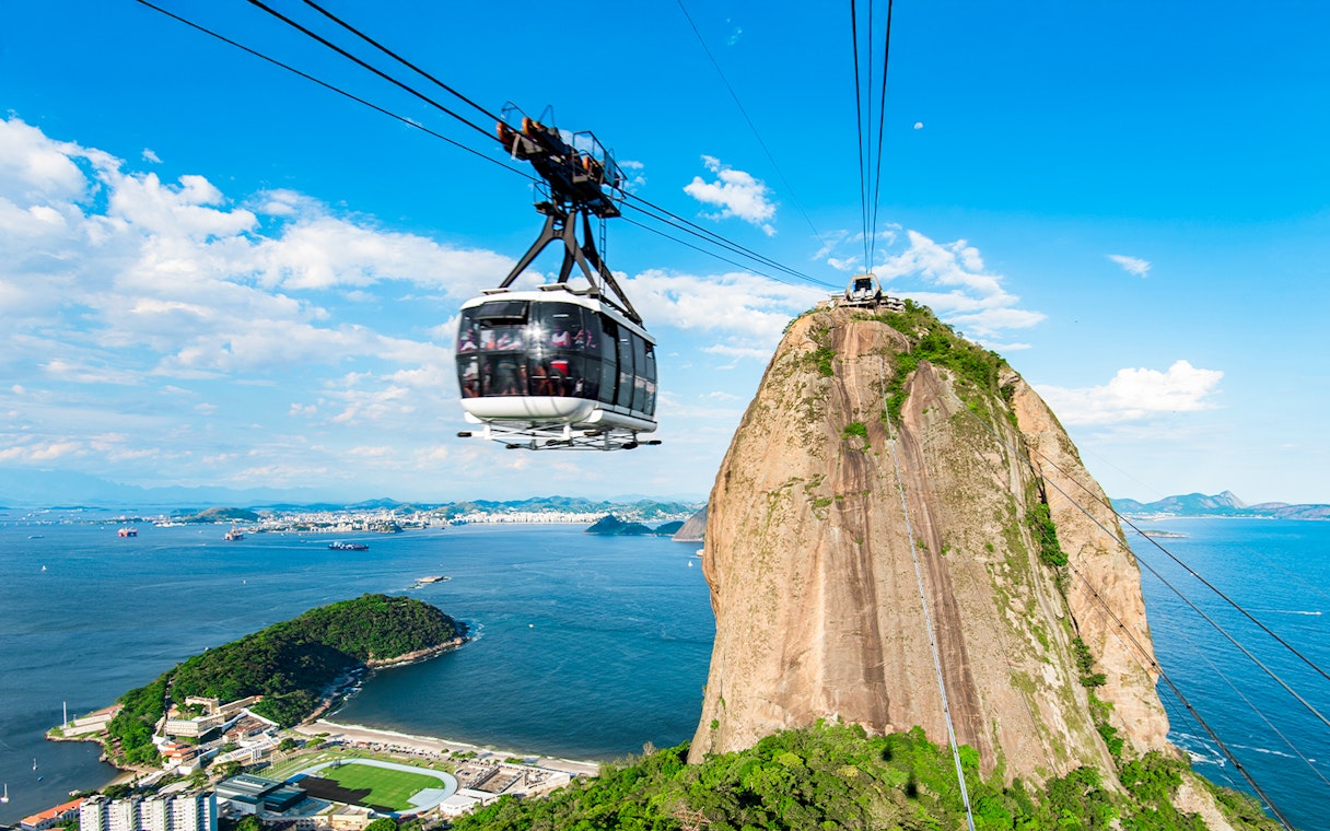 Cable car ascending Sugarloaf Mountain, Rio de Janeiro, with ocean view.