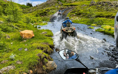 ATVs crossing a stream on the Twin Peaks tour with mountain views, Reykjavik.