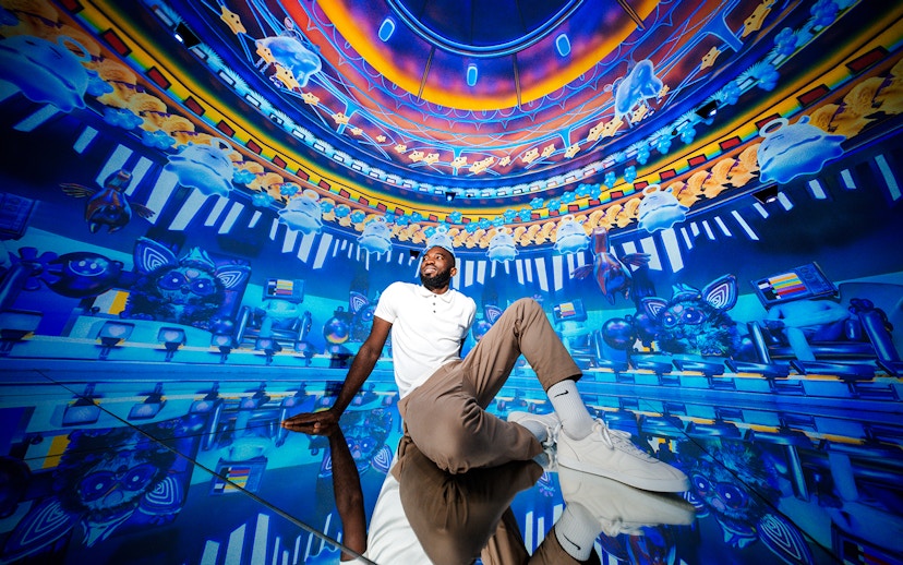 Man sitting in immersive digital art room at House of Hype, Dubai.