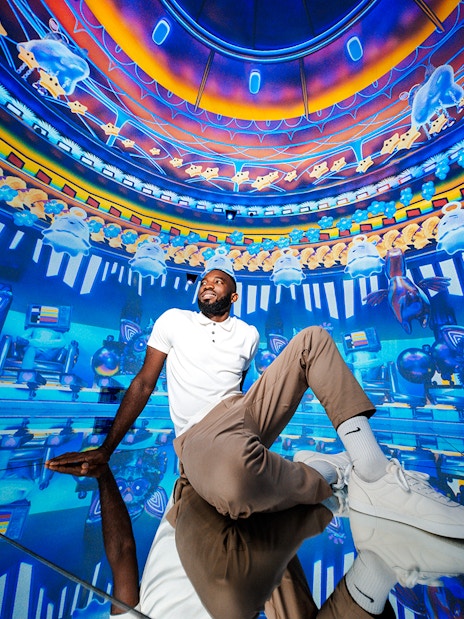 Man sitting in immersive digital art room at House of Hype, Dubai.