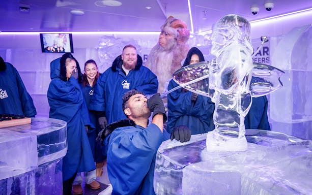 Visitors enjoying drinks at IceBar Surfers Paradise with ice sculptures.