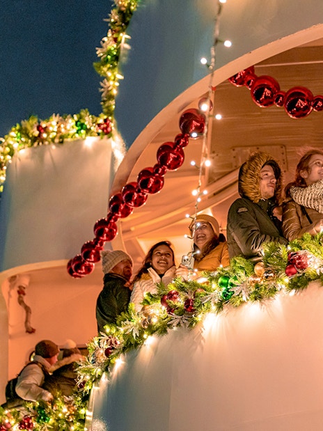 Passengers enjoy festive lights on Circle Line Harbor Lights Cruise.