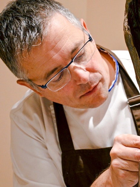 Chef crafting chocolate sculpture at Chocolate Museum Paris exhibit.