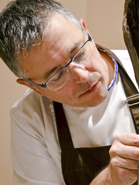 Chef crafting chocolate sculpture at Chocolate Museum Paris exhibit.