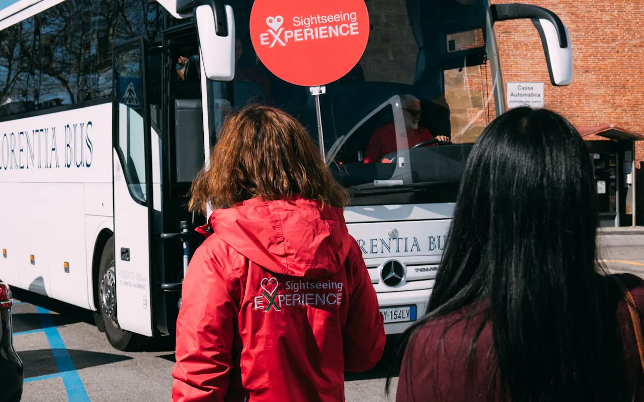 Tourists boarding a sightseeing bus for the Chianti Half Day Tour from Florence.