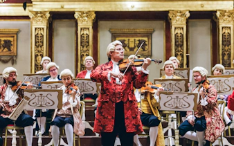 Musicians in period costumes performing at a Mozart Orchestra Concert.