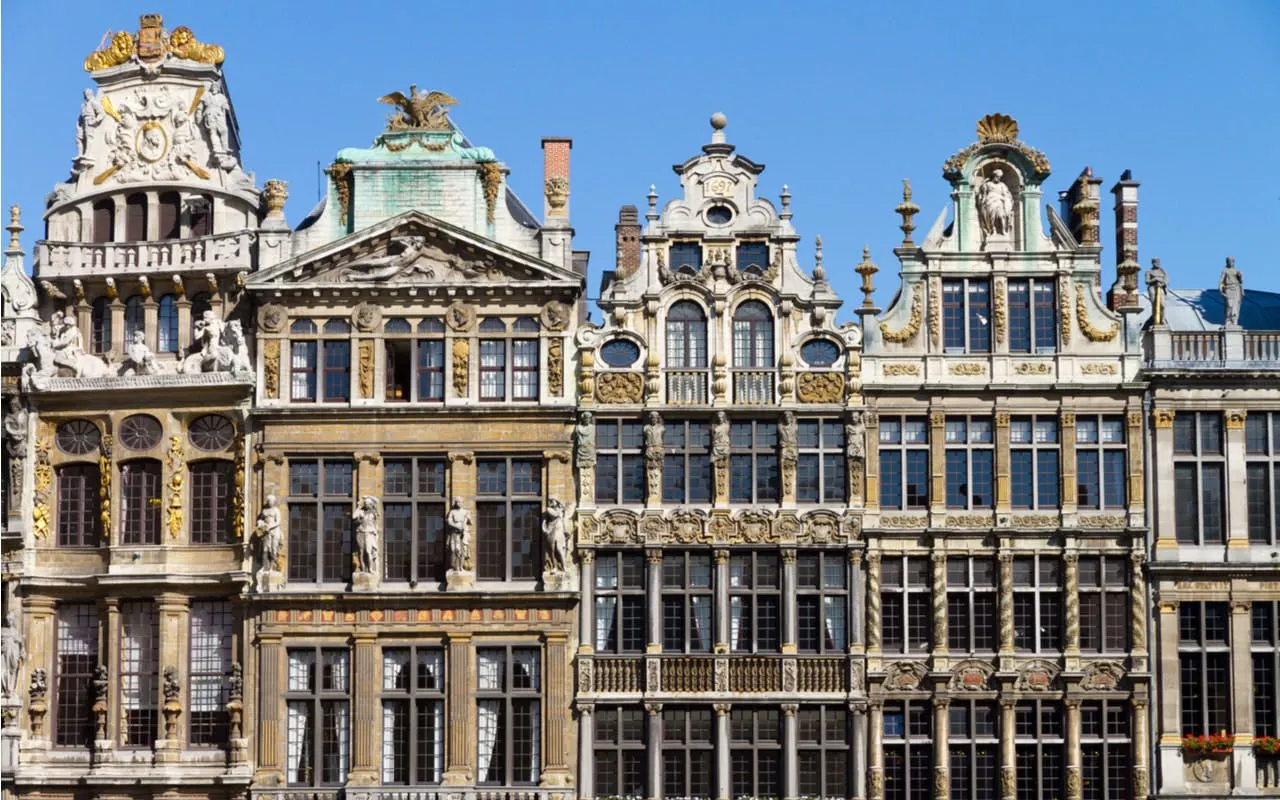 Ornate guildhalls at Grand Place, Brussels, under clear blue sky.