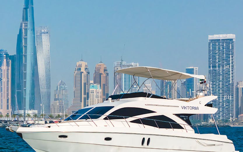 Viktoriia luxury yacht cruising with Dubai skyline in the background.